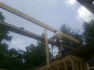 Carpenter setting a ridge beam over a new addition frame — Ice Dam Removal by Roofing Brothers in Browns Valley