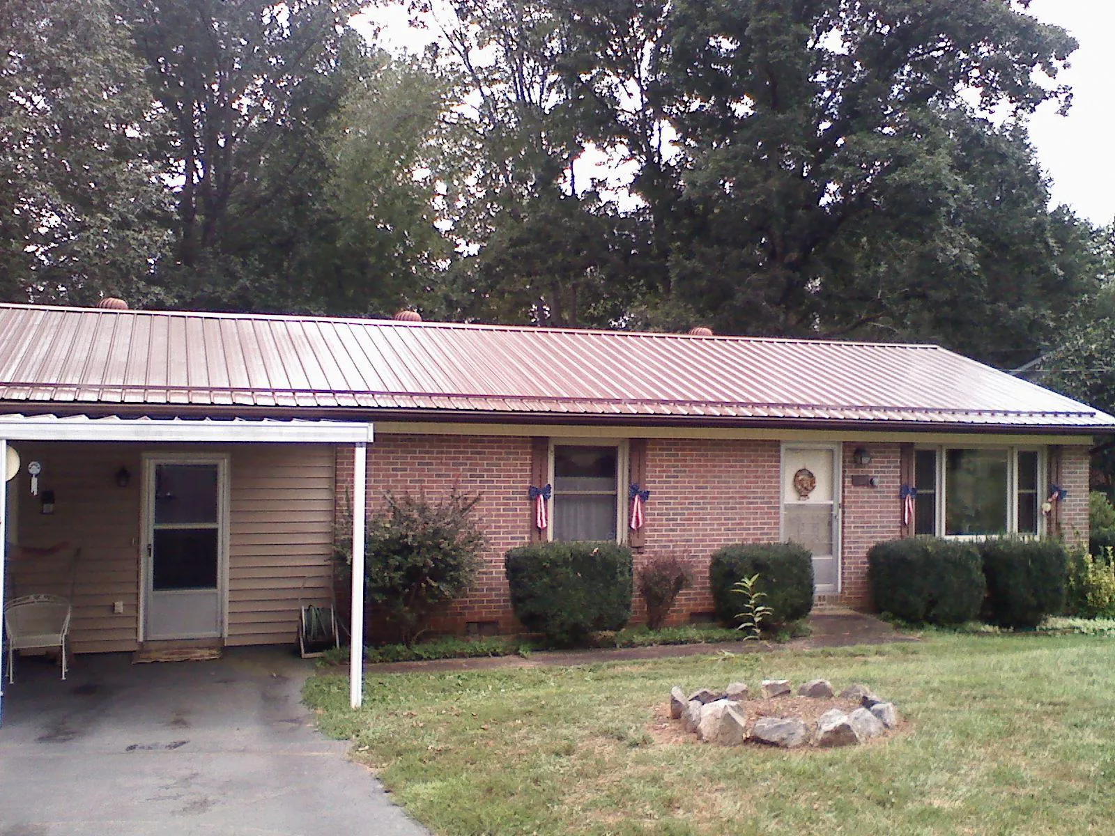 Bronze metal roof and carport on a brick ranch home — Roof Repair work by our crew in Browns Valley